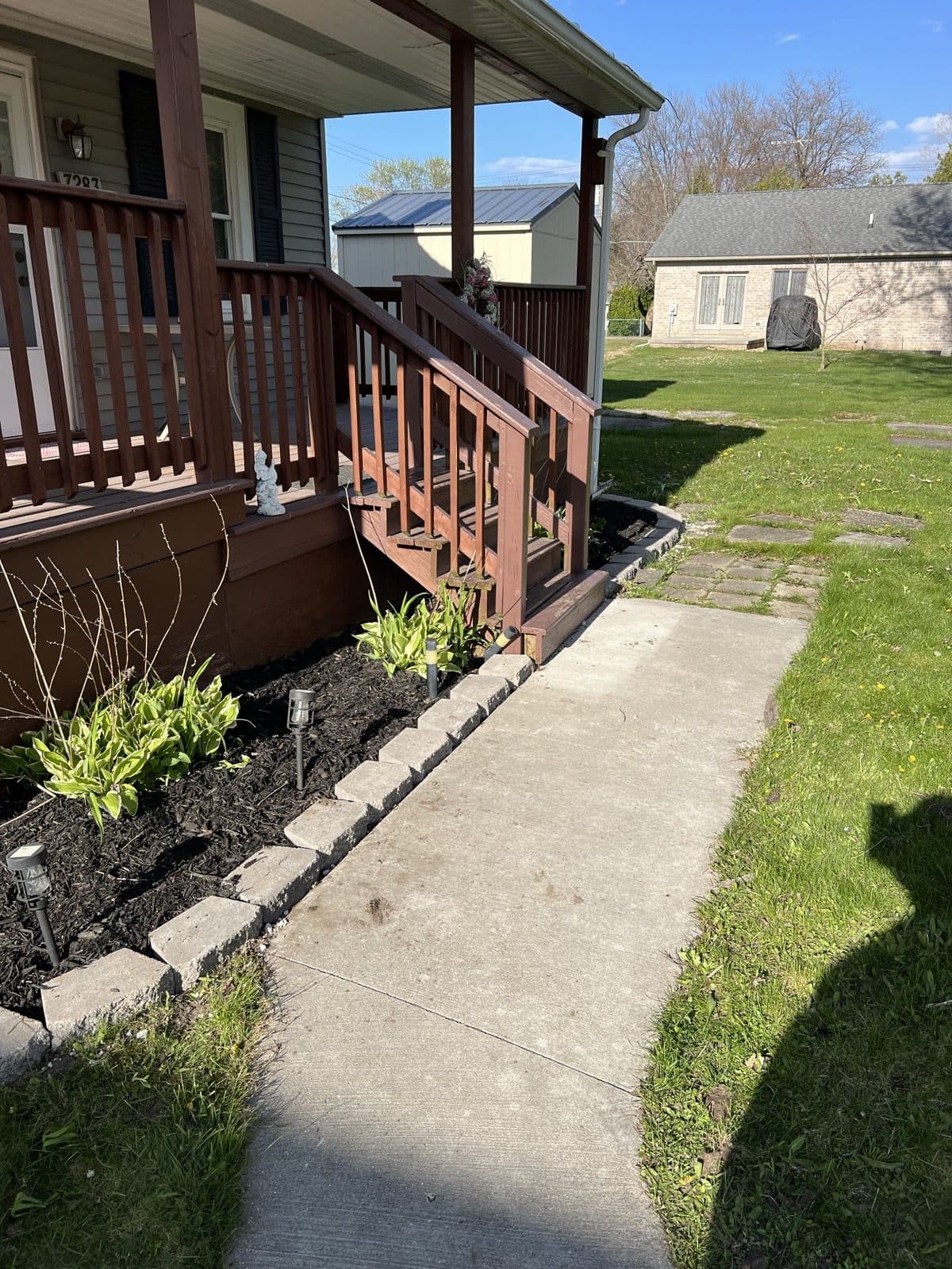 The same backyard bed finished with fresh mulch, new plantings, and clean edging