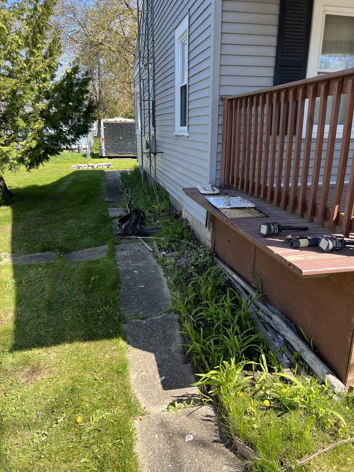 Composite deck with a fresh mulched bed and paver-stone edging along the walkway